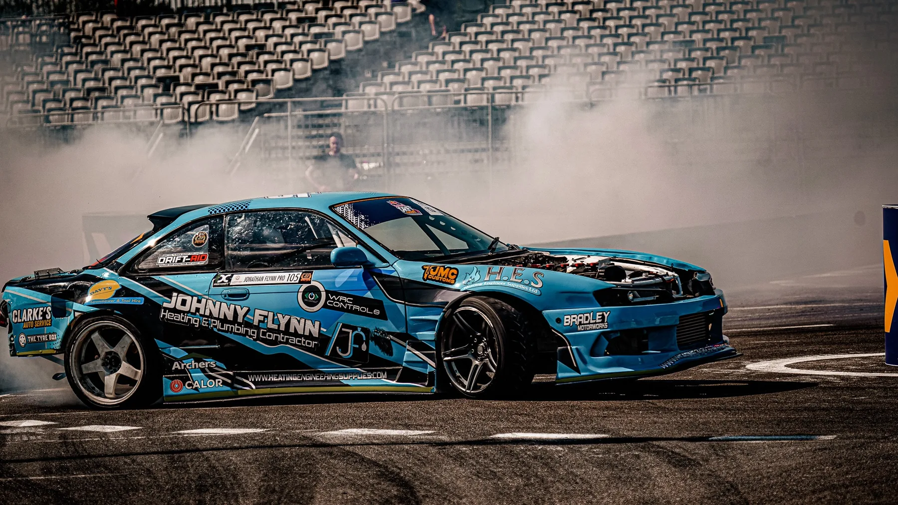 Motorsport car on track beside a flag